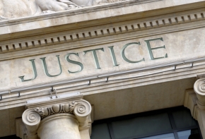 Photo du fronton d'un bâtiment sur lequel le mot justice apparaît